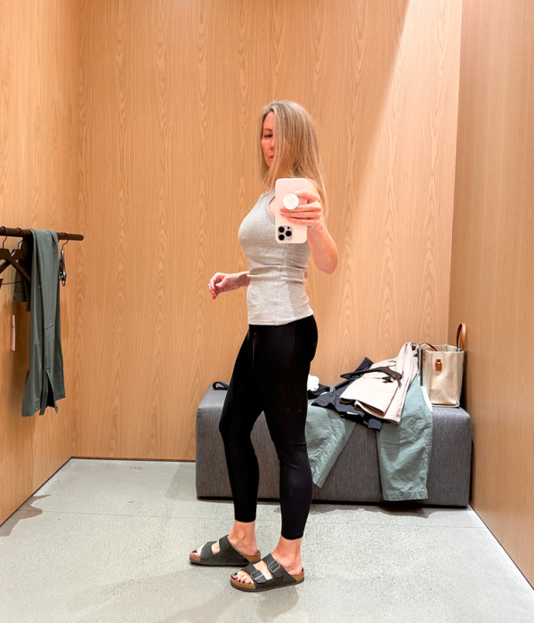 Woman in dressing room trying on yoga pants.