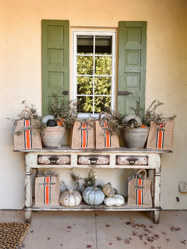 Outside foyer console decorated with fall colors and gift bags.