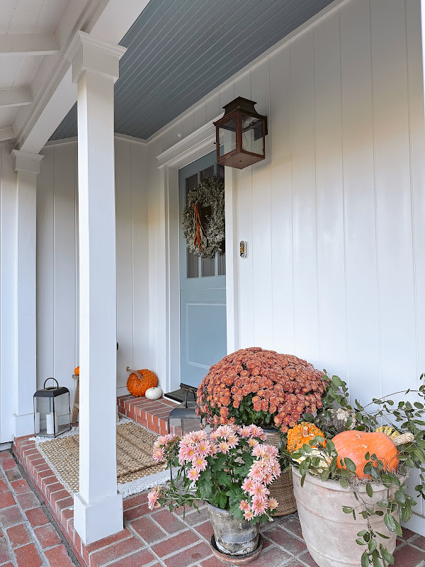 Autumnal front porch and blue Dutch door.