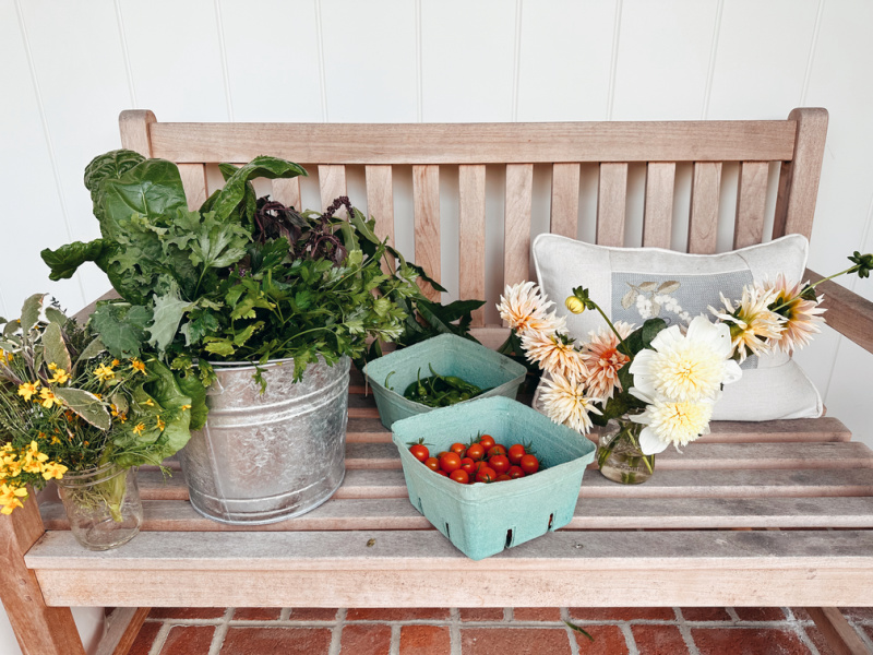 Teak porch bench full of garden harvest.