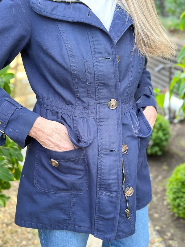 Close up of woman wearing Boden utility jacket in navy.