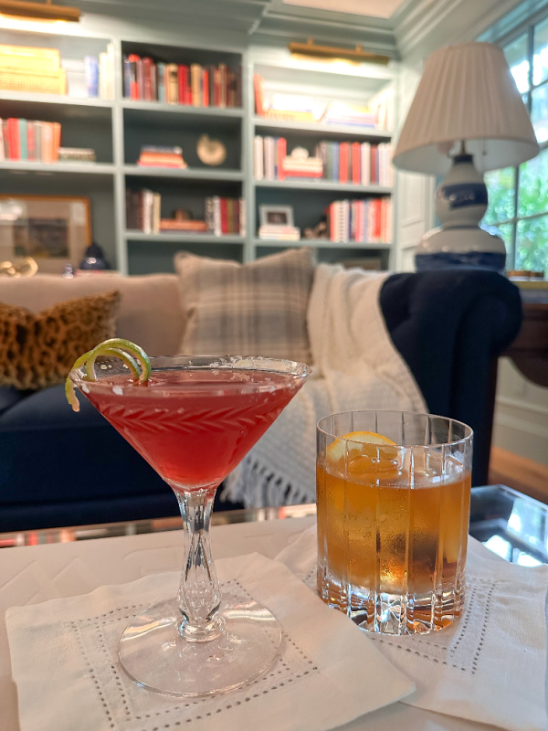 Two cocktails on coffee table in home library.