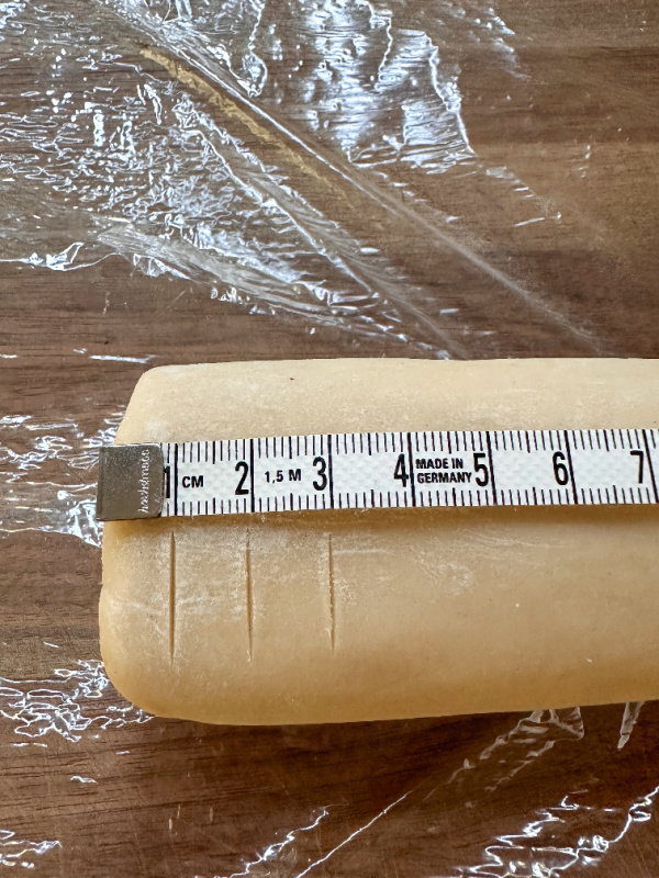 Tube of cookie dough with tape measure on top.