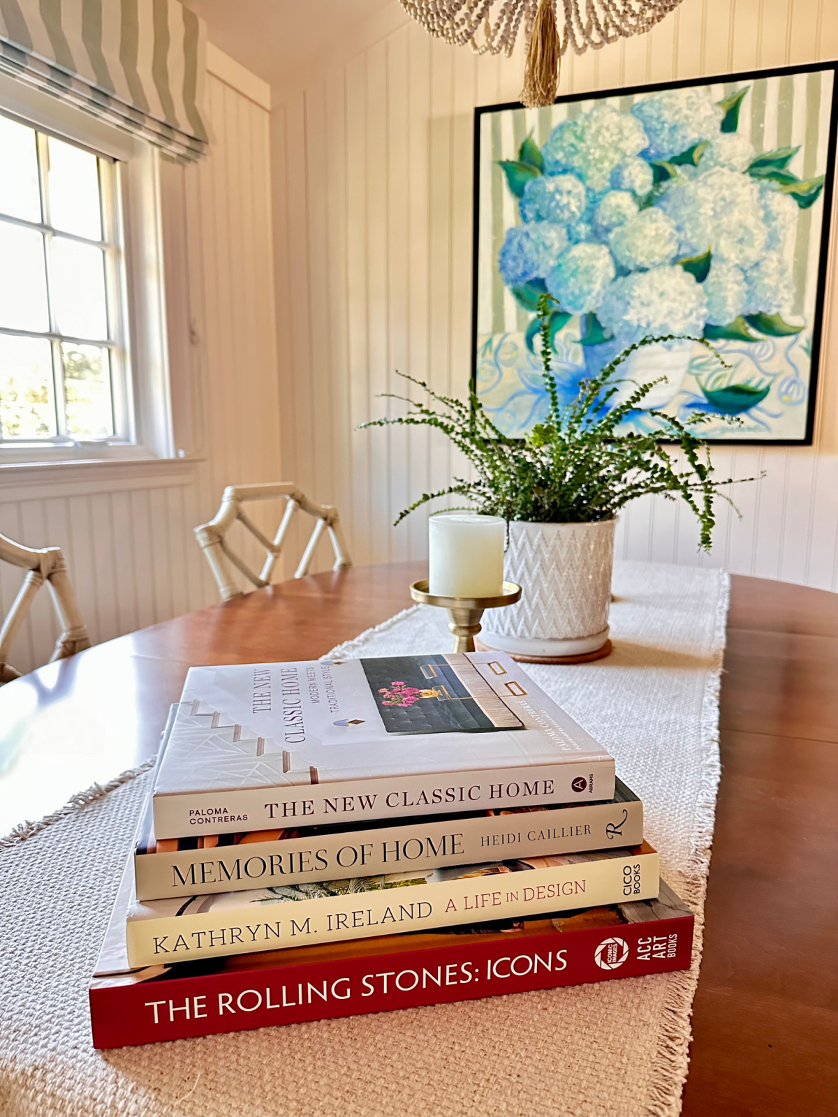 Stack of decor books on dining room table.