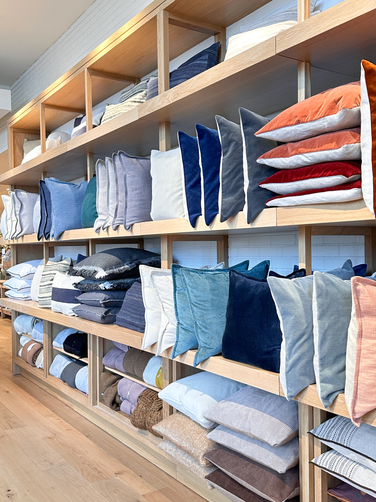 Shelves stocked with colorful pillows at Crate & Barrel.