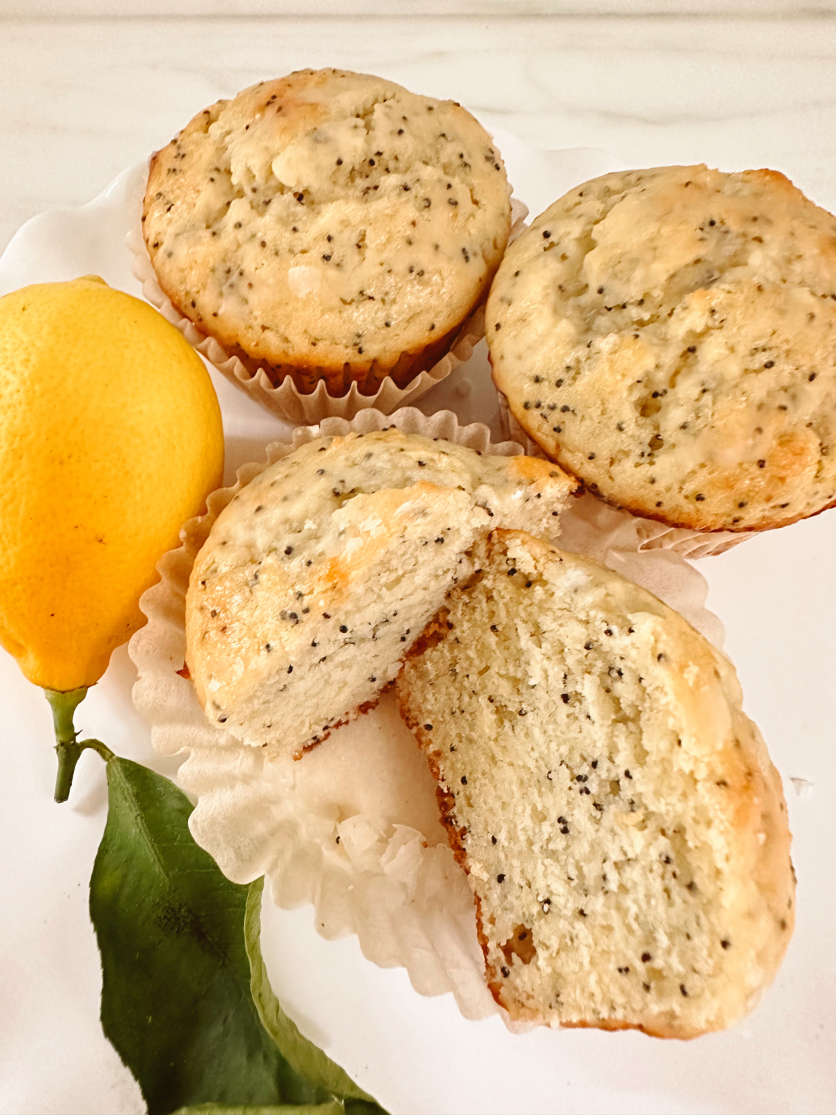 Lemon Poppyseed muffins on a plate.