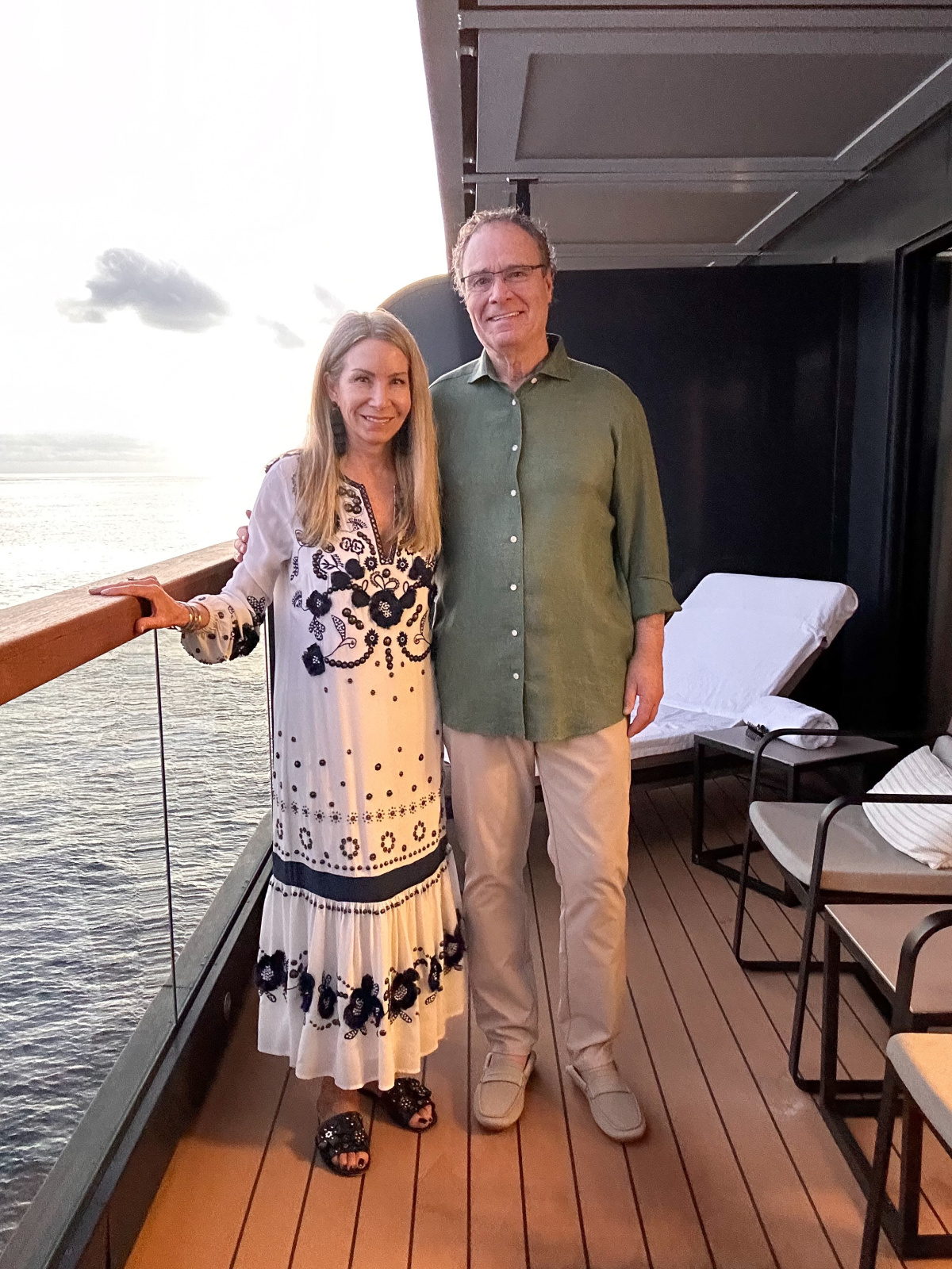 Couple standing on cruise ship suite deck.