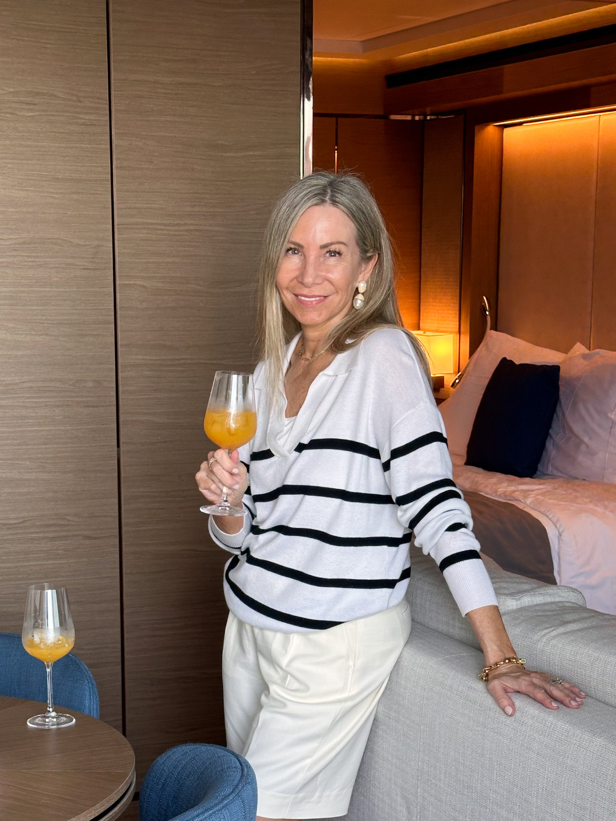Woman holding welcome drink in suite aboard Evrima.