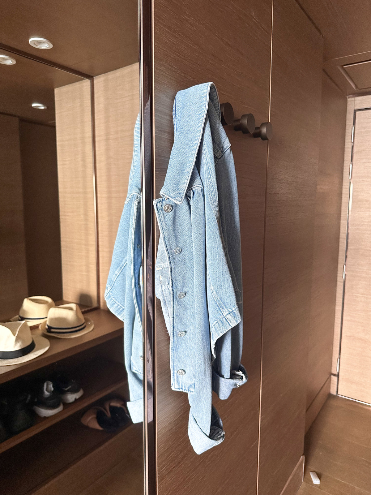 Denim jacket hanging on took in entryway to cruise ship cabin.