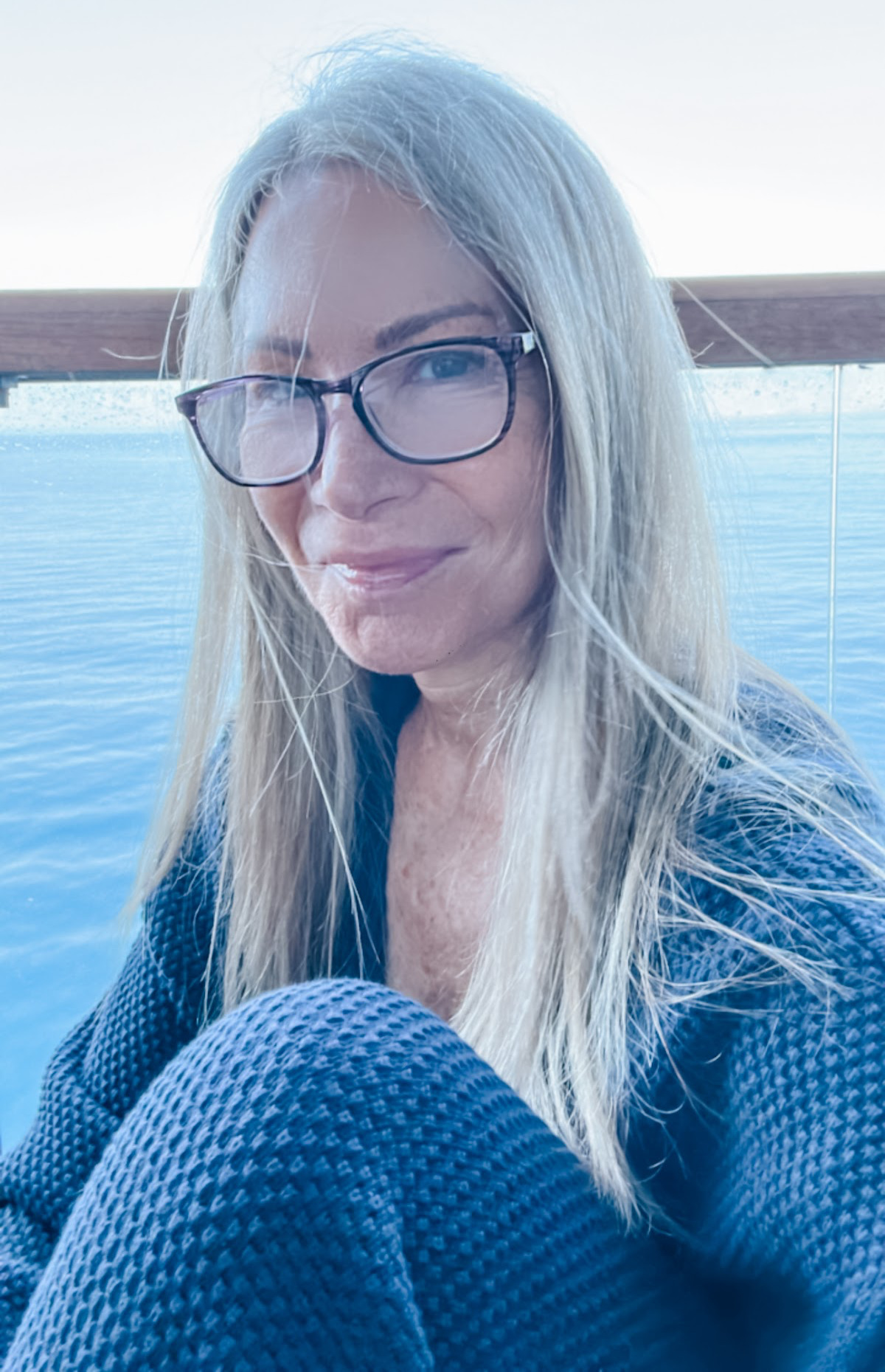 Woman wearing navy blue lounge set on cruise ship terrace.