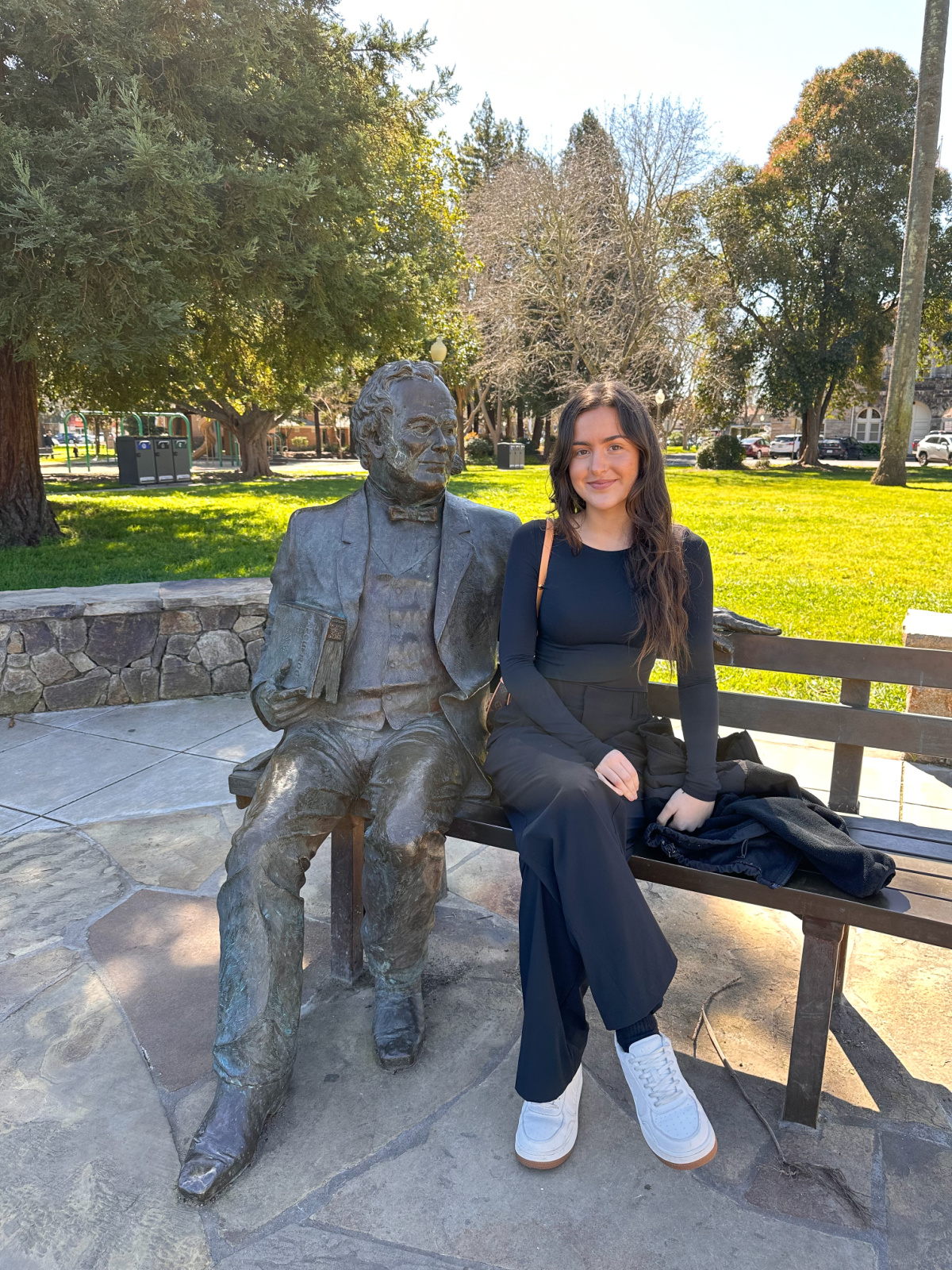 Woman sitting next to statue on bench in Sonoma plaza.