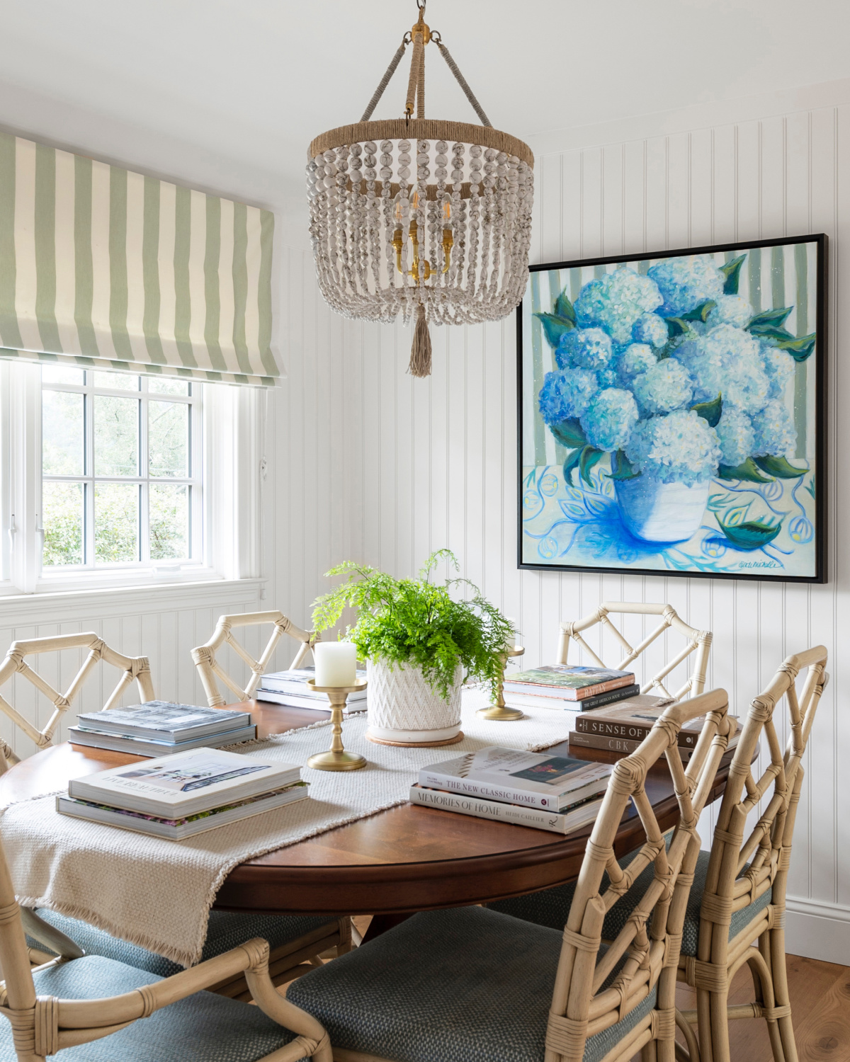 Casual dining room with hydrangea art and books at place settings.