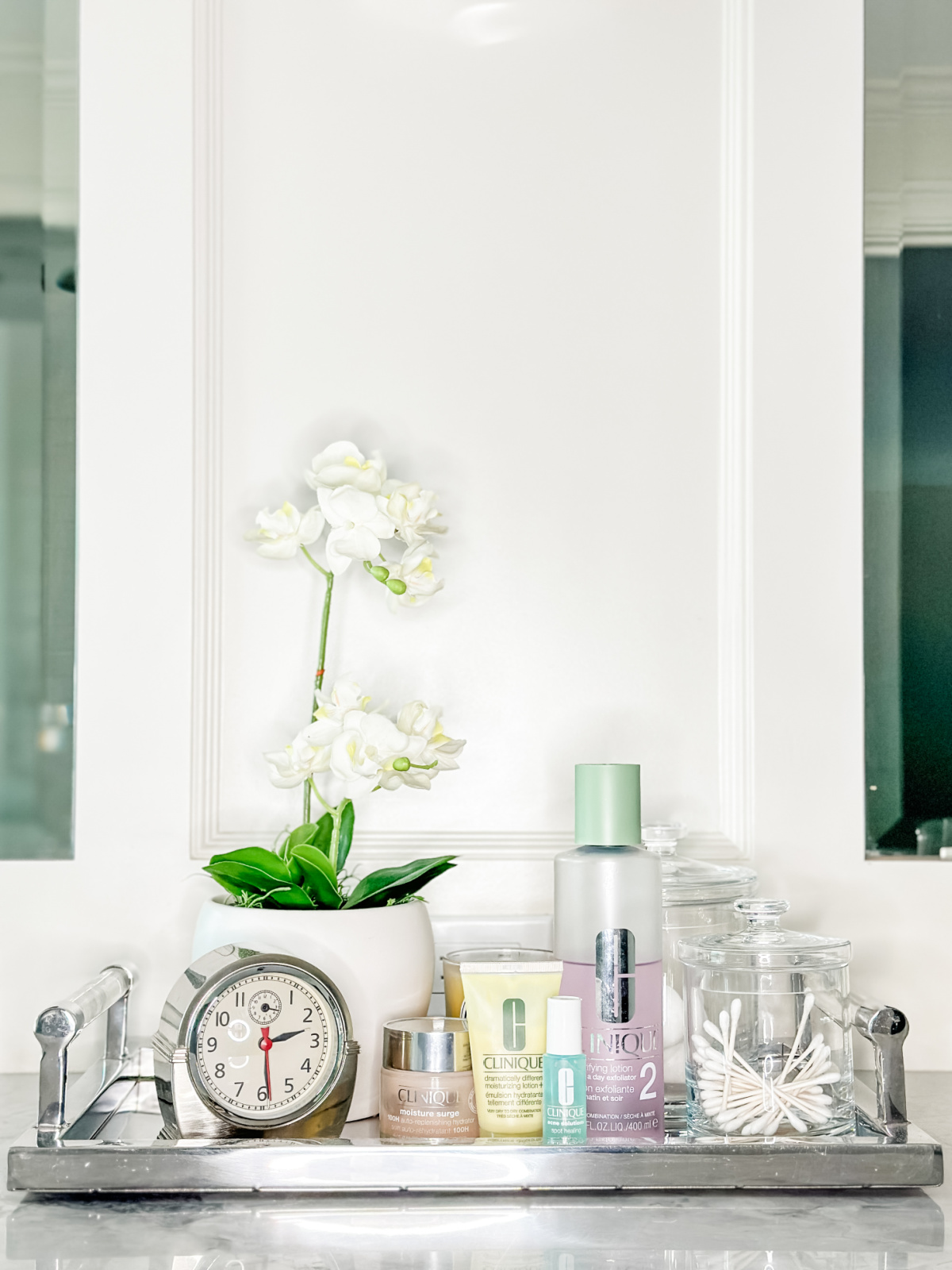 Bathroom vanity tray with Clinique skincare products.