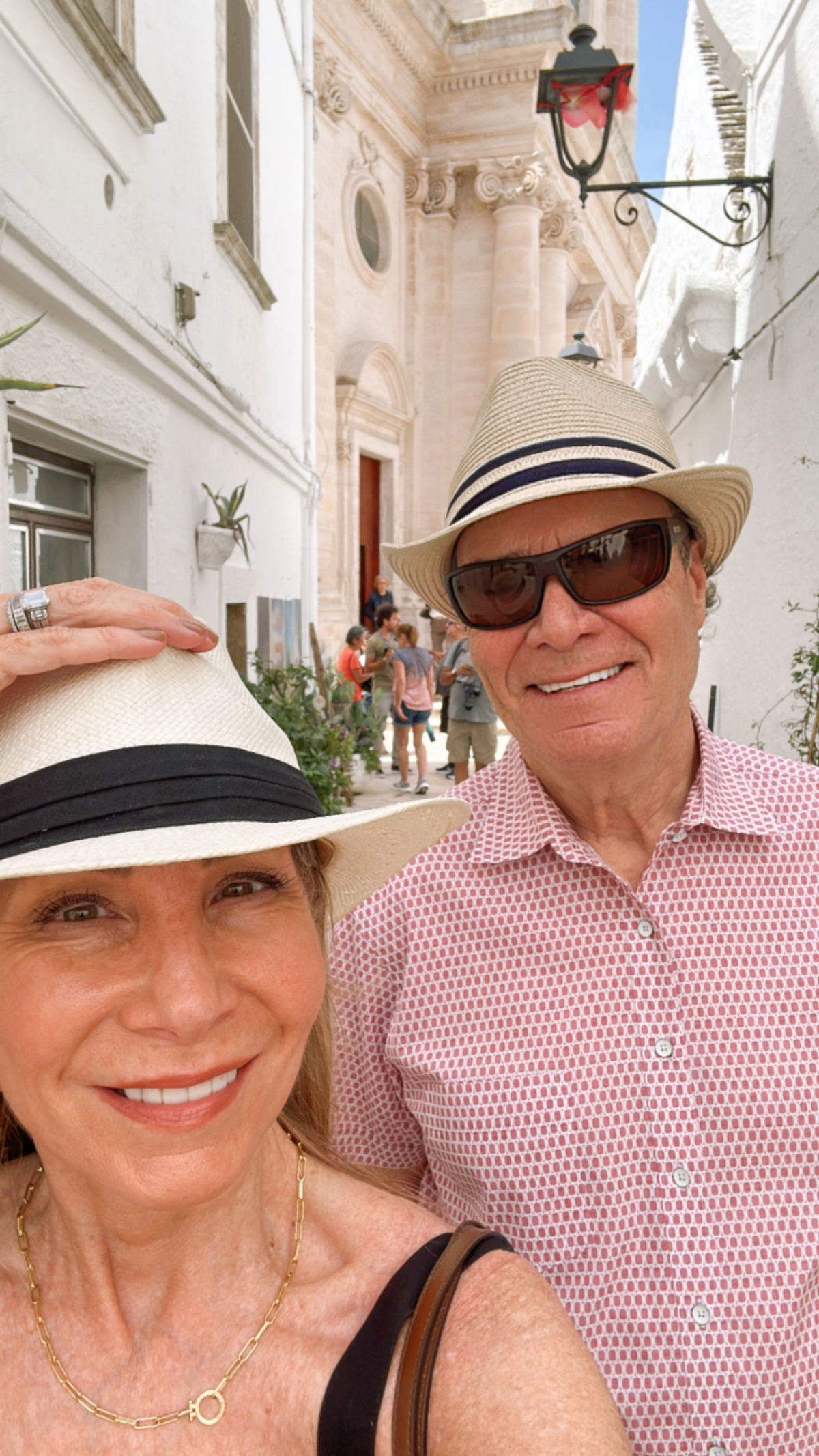 Couple wearing hats taking selfie in Italy.