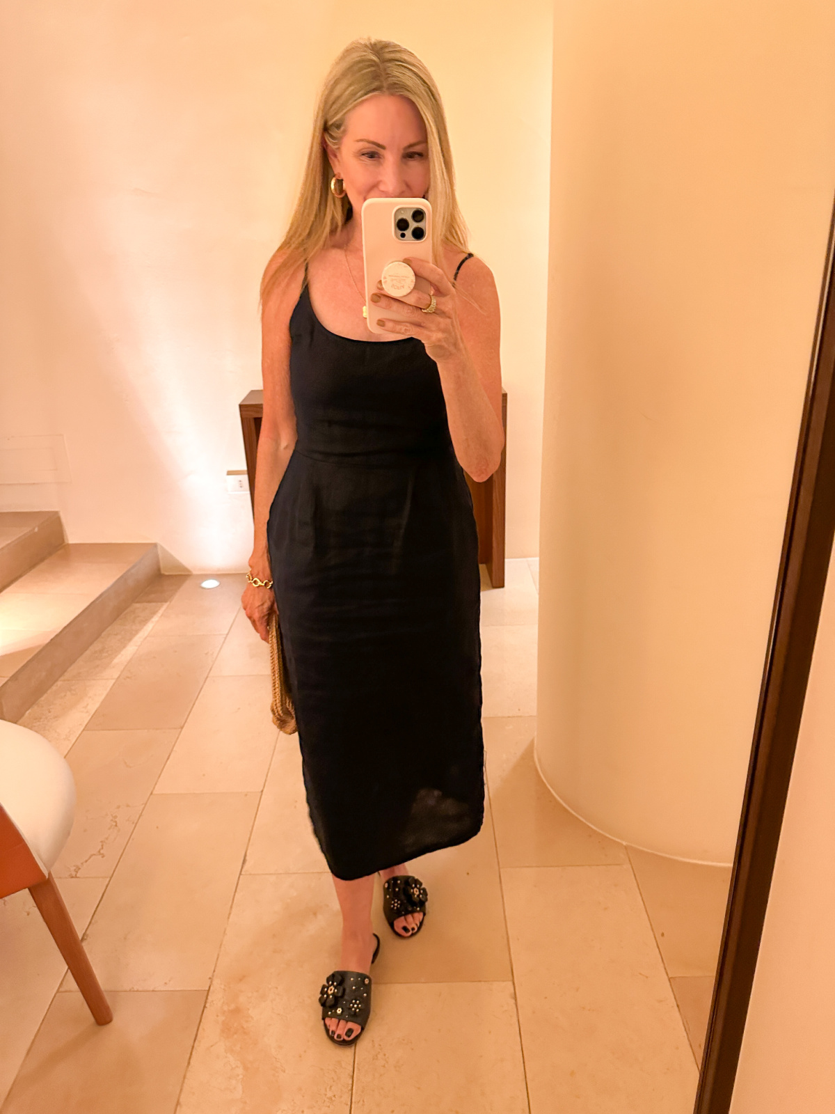 Woman wearing navy blue midi dress taking mirror selfie.